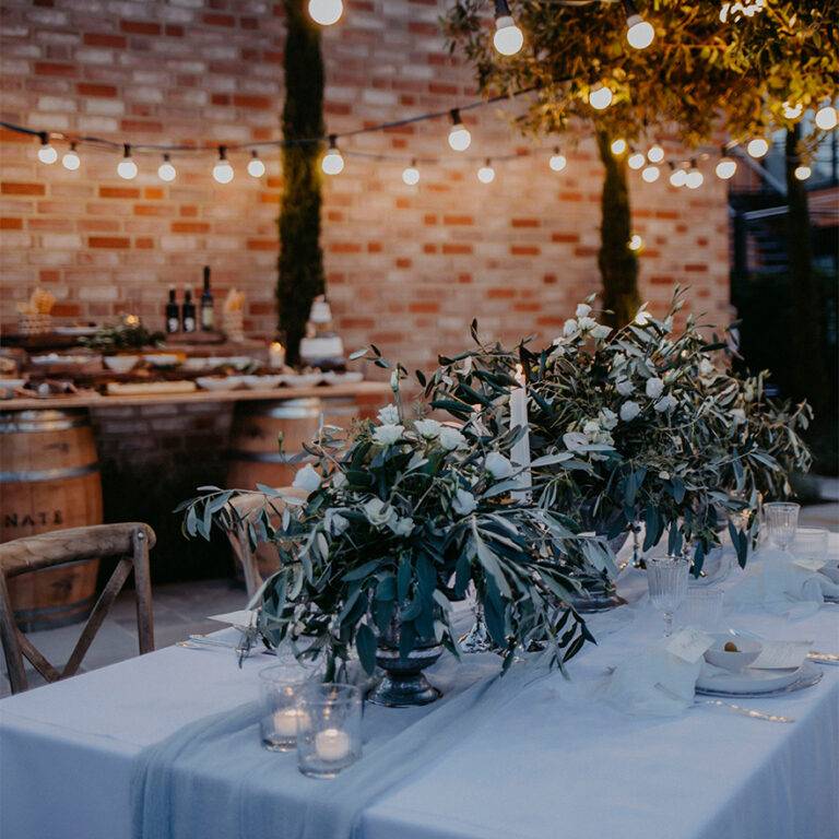 dekorierter Tisch mit vielen Blumen und LIchterketten